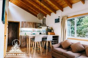 eine Küche mit einem Tisch und einem Sofa in der Unterkunft Cabaña Andes in El Canelo