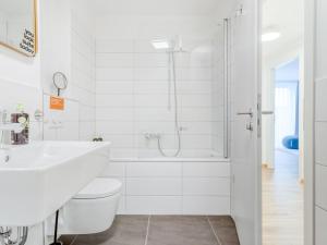 Baño blanco con bañera y lavamanos en limehome Dresden Wallstraße - Digital Access, en Dresden