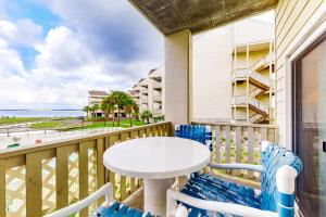 balcón con mesa y sillas y vistas a la playa en Baywatch G1, en Pensacola Beach