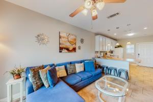 a living room with a blue couch and a kitchen at Baywatch G1 in Pensacola Beach