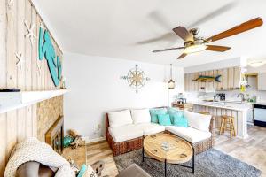 uma sala de estar com um sofá e uma mesa em Sandy Bottom KH107 em Kitty Hawk