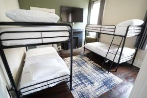 a room with three bunk beds and a television at 3E *Historic Gem* Heart of Southside-Sleeps 10 in Pittsburgh