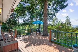 una terraza de madera con mesa y sombrilla en Lake View Getaway, en Hayden