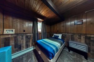 um quarto com uma cama num chalé de madeira em White Mountain Escape em Bartlett