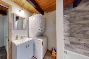 uma casa de banho com um lavatório e um frigorífico em White Mountain Escape em Bartlett