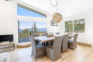 a dining room with a table and chairs and a television at Blue Water in Garden City