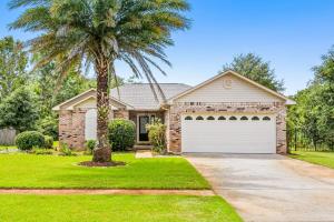 a house with a palm tree and a garage at Pleasant Palms in Navarre