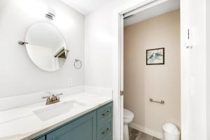 a white bathroom with a sink and a mirror at Sea Mist Cottage in Newport +19 photos