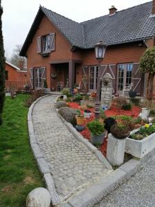 a garden in front of a house with flowers at Chambres chez Nanou avec petit déjeuner in Chimay