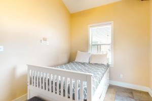 a small bedroom with a crib and a window at Coastal Cabana in Crystal Beach