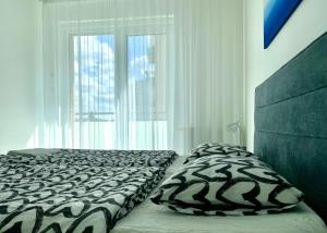 een slaapkamer met een bed en een groot raam bij TopBeer - Stein in Bratislava