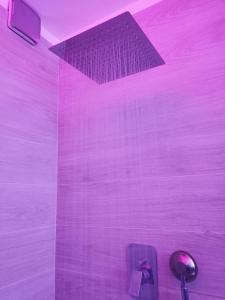 baño con pared morada y techo en Flamma Apartment - Ski in & Ski Out, en Breuil-Cervinia