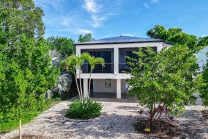 a house with a palm tree in front of it at Pure Aquamarine in Key Largo