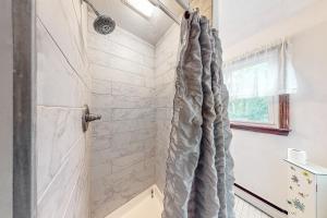y baño con ducha con cortina gris. en Lake Shore Living, en Falmouth 17 fotos más