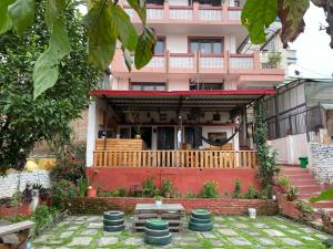 a house with a porch and some plants in the yard at Birds Nest Hostel in Kathmandu