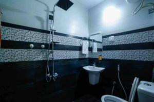 uma casa de banho com um chuveiro, um lavatório e um WC. em Posh 7 BHK at BELLJEM Homes in Thrissur city em Thrissur