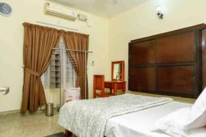 a bedroom with a large bed and a window at Posh 7 BHK at BELLJEM Homes in Thrissur city in Trichūr