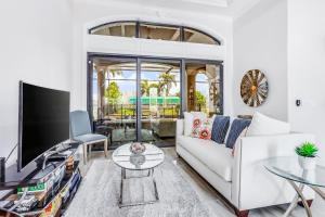 een woonkamer met een witte bank en een tv bij Cape Coral Majesty in Cape Coral