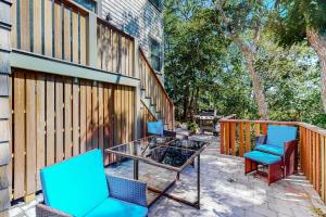 a patio with chairs and a table and a fence at Ptown Treehouse in Provincetown