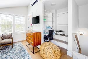 a living room with a dresser and a tv at Ptown Treehouse in Provincetown