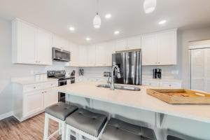 a kitchen with white cabinets and a counter with stools at Blue Haven in Panama City Beach