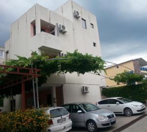 a white building with cars parked in front of it at Apartments Bojanic in Bar
