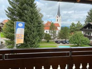 a view of a church from a window with a flag at Gasthof Rössle in Sulzberg