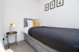 een slaapkamer met een groot bed en een zwarte deken bij No2 Marina Walk by Stay South Wales -FREE Parking in Landore