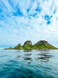 an island in the ocean with rocks in the water at Røst Bryggehotell in Røst