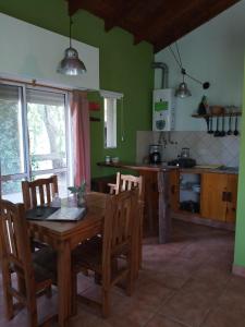 a kitchen with a wooden dining table and chairs at Casas Serranas Margaritas in Sierra de la Ventana
