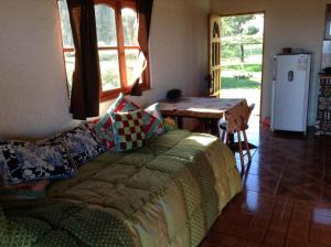 a living room with a couch and a table with a refrigerator at Cabaña Oreko in Hanga Roa