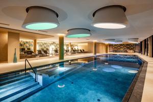 una piscina con acqua blu nella hall dell'hotel di ARIA Retreat & SPA - The Leading Hotels of the World, located within Parco San Marco Resort a Porlezza