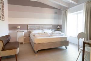 a bedroom with a large bed and a chair at Casa Giardini in Verona