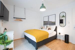1 dormitorio con 1 cama con manta amarilla en limehome Ingolstadt Bauhofstraße en Ingolstadt