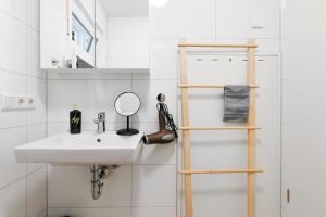 a white bathroom with a sink and a mirror at limehome Ingolstadt Bauhofstraße in Ingolstadt