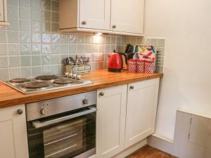 a kitchen with white cabinets and a stove top oven at 2 Farfield Row in Sedbergh