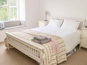una camera da letto con un grande letto bianco con asciugamani di 2 Farfield Row a Sedbergh