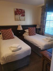 a room with two beds with towels on them at Ty Dre Town House in Caernarfon