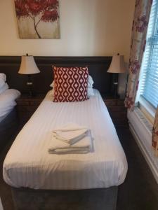 a bedroom with a bed with two towels on it at Ty Dre Town House in Caernarfon