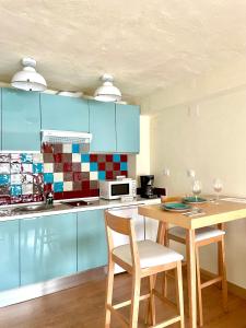 a kitchen with blue cabinets and a table and chairs at Apartamento CEO in Ronda