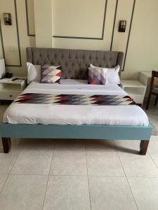 un letto con struttura blu in una stanza di Avesta Hotel a Kampala