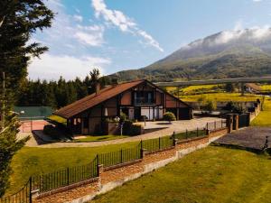 una casa con una valla delante de una montaña en BARANDI URBASA CASA RURAL, en Olazagutía