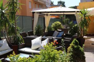 a patio with wicker chairs and an umbrella at Hotel Berna in Eraclea Mare