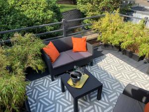 a patio with a couch and a table with orange pillows at Notting Hill 3BR Townhouse with ensuite bathrooms - Ideal for families in London