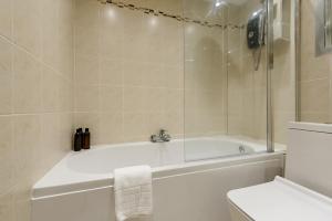 a bathroom with a white tub and a toilet at The Old Town Cockburn Apartment in Edinburgh