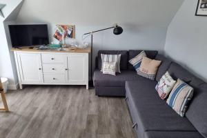 a living room with a couch and a tv at 2 Bedroom Seafront Apartment in Felixstowe