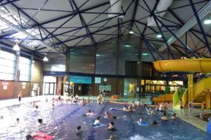 a group of people swimming in a swimming pool at 2 Bedroom Seafront Apartment in Felixstowe