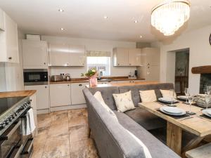 een keuken en een woonkamer met een bank en een tafel bij Tree Tops in Alston