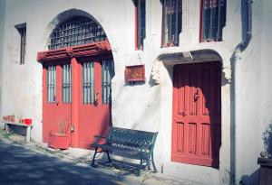 a bench sitting in front of a building with red doors at Les Trois Maillets, Monument Historique in Orléans