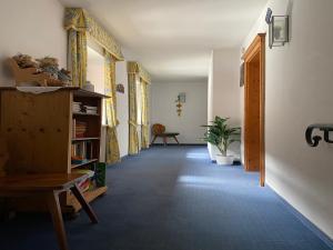 un corridoio con libreria e sedia in una stanza di Gasthof Rössle a Sulzberg